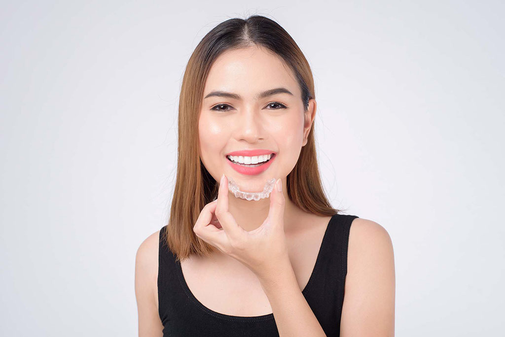 Man smiling while using clear aligners to invisibly straighten his teeth in Beverly Hills 