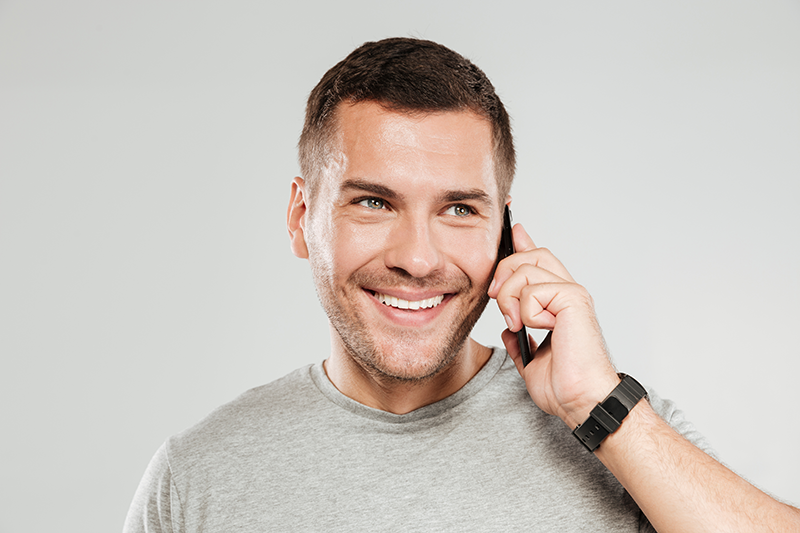 A gentleman at a café smiling after orthodontic treatment from The Orthospaceship